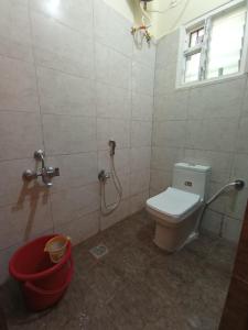 蒂魯吉拉帕利的住宿－Sri Arangan Kudil Rooms，一间带卫生间、窗户和桶的浴室