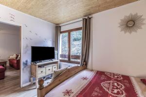 a bedroom with a large bed and a tv at Nid Douillet in Gréolières