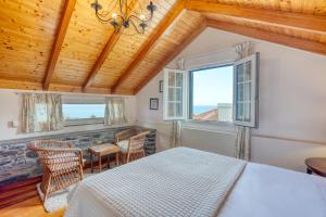 a bedroom with a bed and a table and chairs at Quinta da Vila in Porto da Cruz