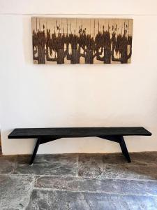 a black bench in front of a wall with a painting at Slowly-Com Vagar in Mourão