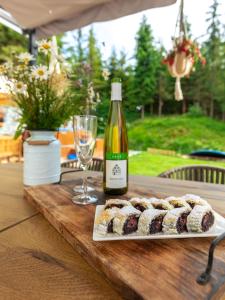 a table with a plate of sushi and a bottle of wine at Chalet Ester - Luxury Provençal House in Orava in Námestovo