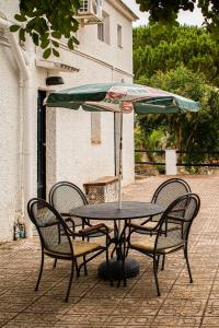 Godelleta的住宿－Casa Mas Montañas - Gris，一张桌子、两把椅子和一把伞