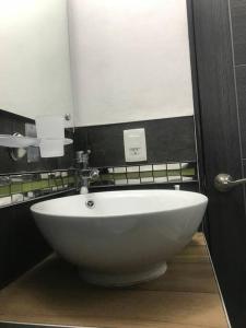 lavabo blanco en el baño con espejo en Habitación Irving confortable con baño privado en Ciudad de México