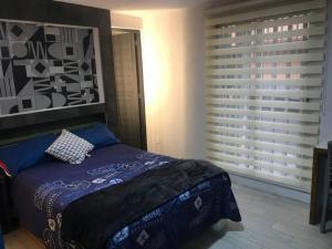 a bedroom with a bed and a large window at Habitación Irving confortable con baño privado in Mexico City