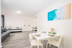 un soggiorno bianco con tavolo e sedie bianchi di Modern Apartments near Bottrop a Gladbeck