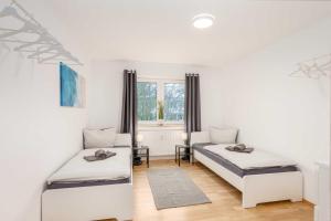 a white room with two beds and a window at Modern Apartments near Bottrop in Gladbeck