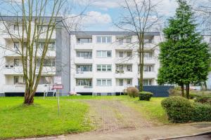 un gran edificio blanco con árboles delante de él en Modern Apartments near Bottrop, en Gladbeck