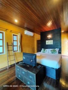 a bedroom with a bed and a desk with a tv at Keereeta Resort in Ko Chang
