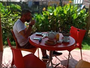 a man sitting at a table with a cup of tea at Nageran Homestay in Dambulla