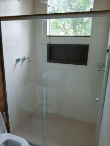 a bathroom with a glass shower with a sink at Casa no Condomínio Naútico Porto da Pedra em Ijaci in Macaia