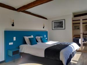 - une chambre bleue et blanche avec un grand lit dans l'établissement Hotel Le Moulin Des Ramiers, à Crupet