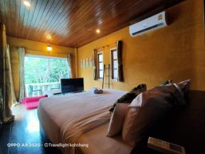 a bedroom with a large bed and a window at Keereeta Resort in Ko Chang