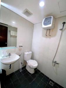 a bathroom with a toilet and a sink at Skyland City Hotel Jatinangor in Cilimus 2