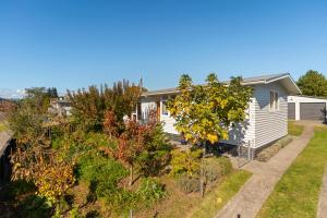 a house with a garden in front of it at The Orchard House - Turangi Holiday Home in Turangi