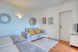 ein Wohnzimmer mit einem blauen Sofa und gelben Kissen in der Unterkunft Quinta da Vila in Porto da Cruz