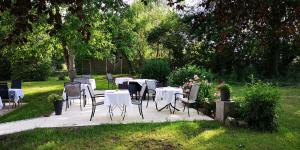 eine Gruppe von Tischen und Stühlen in einem Garten in der Unterkunft Hotelpension Pfarrhaus in Alt Schwerin
