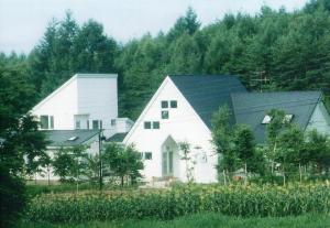 a large white barn with a black roof at St Village in Hokuto