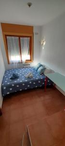 1 dormitorio con cama con sábanas azules y ventana en CASA la PAU en Vilassar de Mar