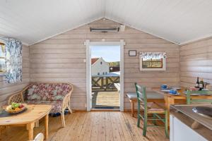 een keuken en een woonkamer met een tafel en stoelen bij First Camp Norsjø Telemark in Akkerhaugen