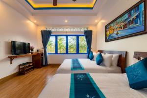 two beds in a room with a tv at LOCAL BEACH FRONT VILLAS in Tân Thành (1)