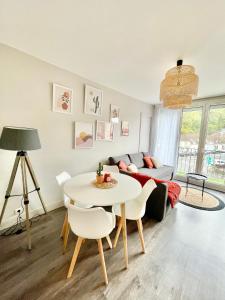 ein Wohnzimmer mit einem Tisch und einem Sofa in der Unterkunft Idéal gare aéroport centre-ville Beauvais in Beauvais