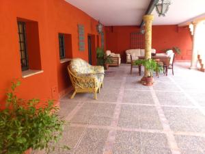 un patio con sillas y mesas en una pared naranja en Ala Mexicana, en Huércal-Overa