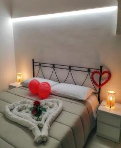 ein Schlafzimmer mit einem Bett mit zwei roten Herzen darauf in der Unterkunft Home Pedra in Ceglie Messapica