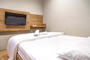 een slaapkamer met een bed en een flatscreen-tv bij 3J Living in Binong