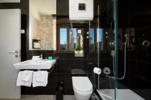 La salle de bains est pourvue de toilettes, d'un lavabo et d'une douche. dans l'établissement Bernardi Rooms, à Split