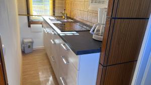 a kitchen with white cabinets and a black counter top at Bungalow, Nähe Ilsenburg und Wernigerode in Veckenstedt