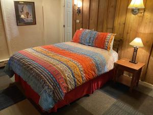 1 dormitorio con 1 cama y 1 mesa con lámpara en The Viking Lodge - Downtown Winter Park Colorado, en Winter Park