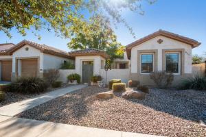 a house with a landscaping in front of a driveway at Elm Casita Apts in Litchfield Park