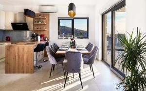 una cucina e una sala da pranzo con tavolo e sedie di Villa Infinity View a Primošten