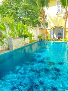 a large swimming pool with blue water in front of a house at Casugria Dutch Residence 1810 in Malacca