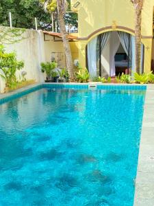a swimming pool with blue water in front of a house at Casugria Dutch Residence 1810 in Malacca