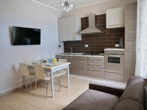 eine Küche mit einem Tisch, Stühlen und einem Sofa in der Unterkunft Casa Salumiere ‐ BICAMERE con posto auto vicinissimo alla spiagga Costa Azzurra in Grado