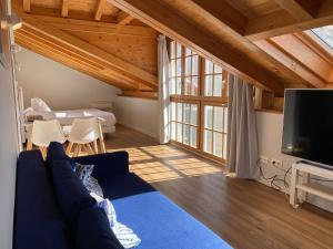 uma sala de estar com um sofá azul e uma televisão em Apartamentos Mundaka Surf Camp em Mundaka