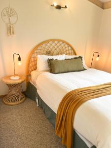 sypialnia z dużym łóżkiem z drewnianym zagłówkiem w obiekcie The PC Cottage w mieście Port Campbell
