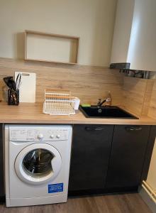 eine Küche mit einer Waschmaschine und einem Waschbecken in der Unterkunft Idéal gare aéroport centre-ville Beauvais in Beauvais