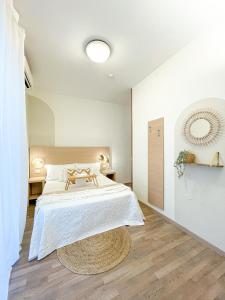 a white bedroom with a large bed and a wooden floor at Americana Beach House in Rimini
