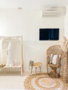a living room with a rattan chair and a couch at Americana Beach House in Rimini