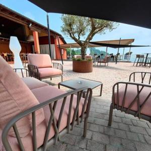 une terrasse avec des chaises, une table et un parasol dans l'établissement Albergo Torre, à Vicence