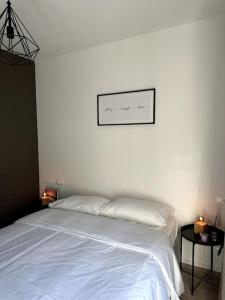 Un dormitorio con una cama blanca y una foto en la pared en Riva 2, en Lugano