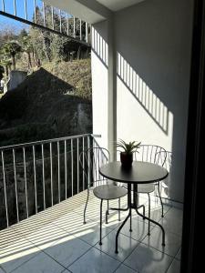 balcón con mesa, 2 sillas y ventana en Riva 2 en Lugano