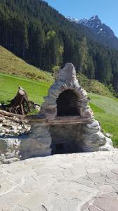 a stone oven sitting on top of a field at Haus am Reh in Gargellen