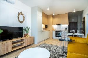 a living room with a large television and a kitchen at ApartamentySnu, Struga Tower Double Gold z parkingiem in Radom