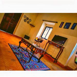een woonkamer met een tafel en een tapijt bij Casa Brooklyn Portuguese Heritage in Saligao
