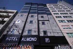 a tall building with a hotel almond sign on it at Almond Hotel Busan Station in Busan