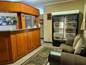 a bar in a room with a couch and a counter at Motel Villa Africa in Polokwane