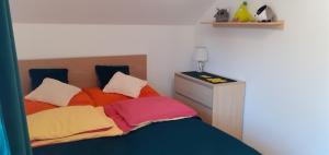 1 dormitorio con 1 cama con almohadas coloridas en Mieszkanko z tarasem, en Limanowa